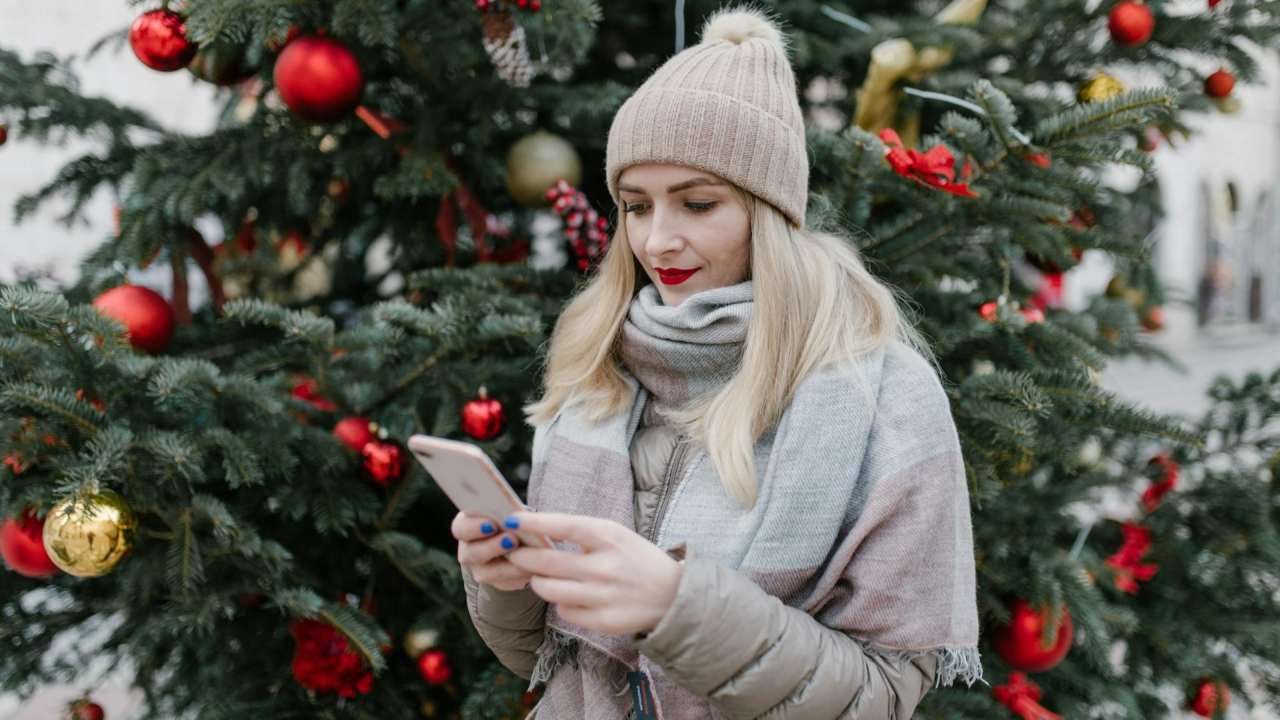 Weihnachten - Girl mit Smartphone vor dem Weihnachtsbaum
