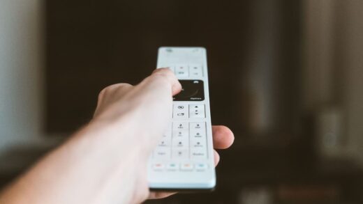 Hand mit Fernbedienung vor einem Fernseher – Disney+ streamt in Deutschland nur noch in 1080p ohne HDR