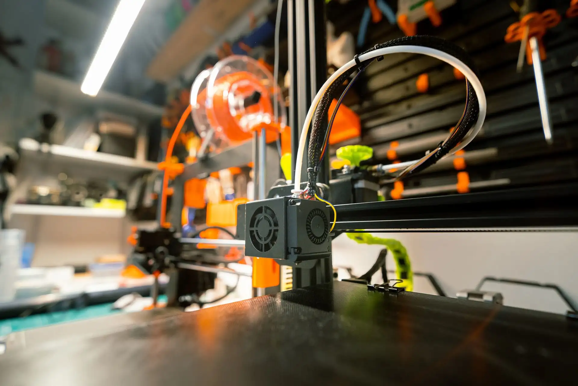 3D-Drucker in einer Werkstatt mit Werkzeug und Filamentspule – Benchy als Testdruck nach Umbau und Kalibrierung