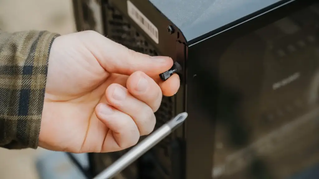 Hand schraubt das Seitenteil eines Desktop-PCs ab