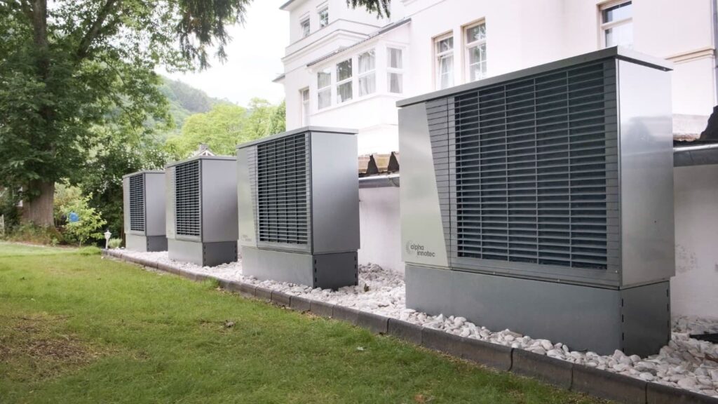 Moderne Wärmepumpe als Außeneinheit an einem Neubau – Kompressortechnik, die Festkörpersysteme langfristig ablösen sollen