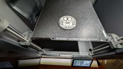 Fertig gedrucktes rundes Bauteil auf der texturierten PEI-Druckplatte eines geschlossenen Elegoo 3D-Druckers