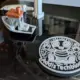 Drei fertige 3D-Drucke nebeneinander: ein Logo-Untersetzer, ein Benchy-Boot und eine gedruckte Vase