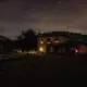 Einzeln stehendes Haus mit warm beleuchteten Fenstern bei Nacht