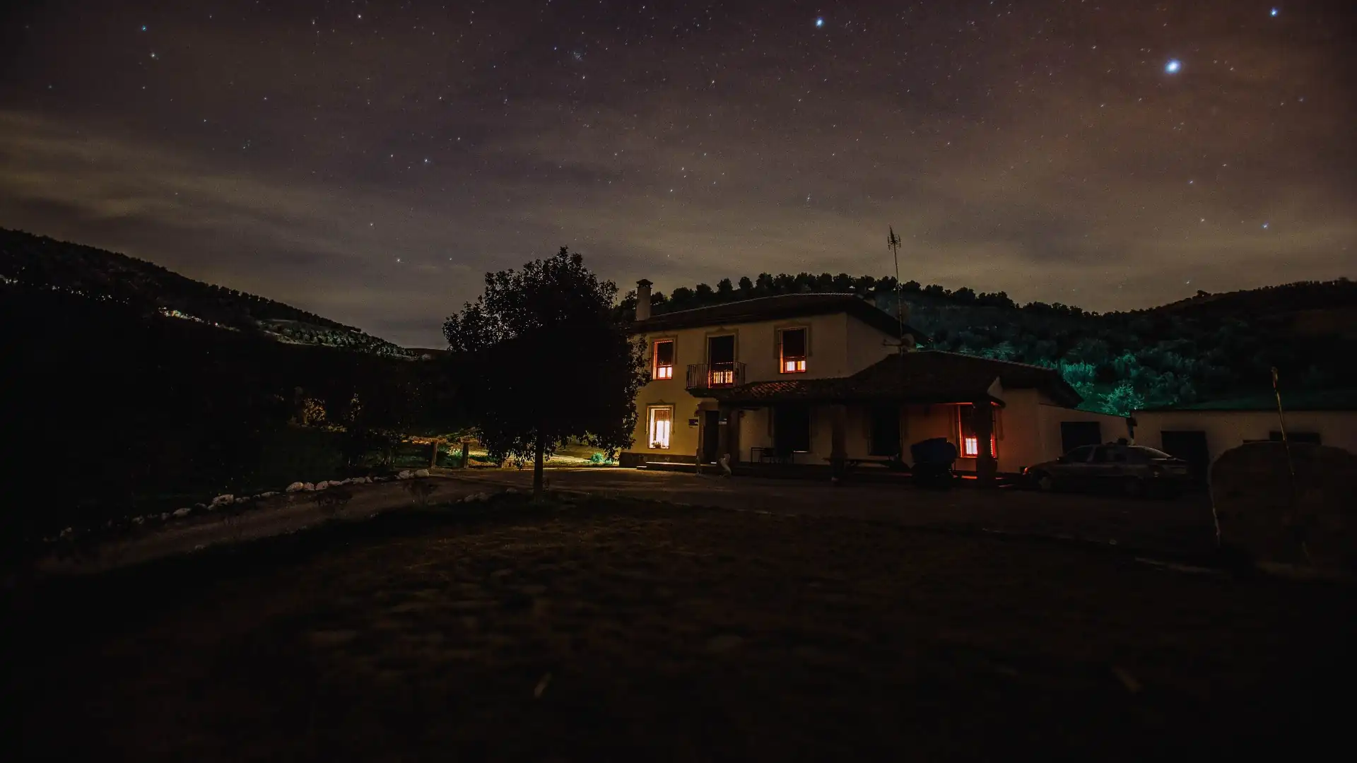 Einzeln stehendes Haus mit warm beleuchteten Fenstern bei Nacht