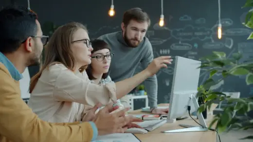 Entwicklerteam bespricht ein KI-Projekt gemeinsam am Laptop im Büro