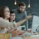 Entwicklerteam bespricht ein KI-Projekt gemeinsam am Laptop im Büro