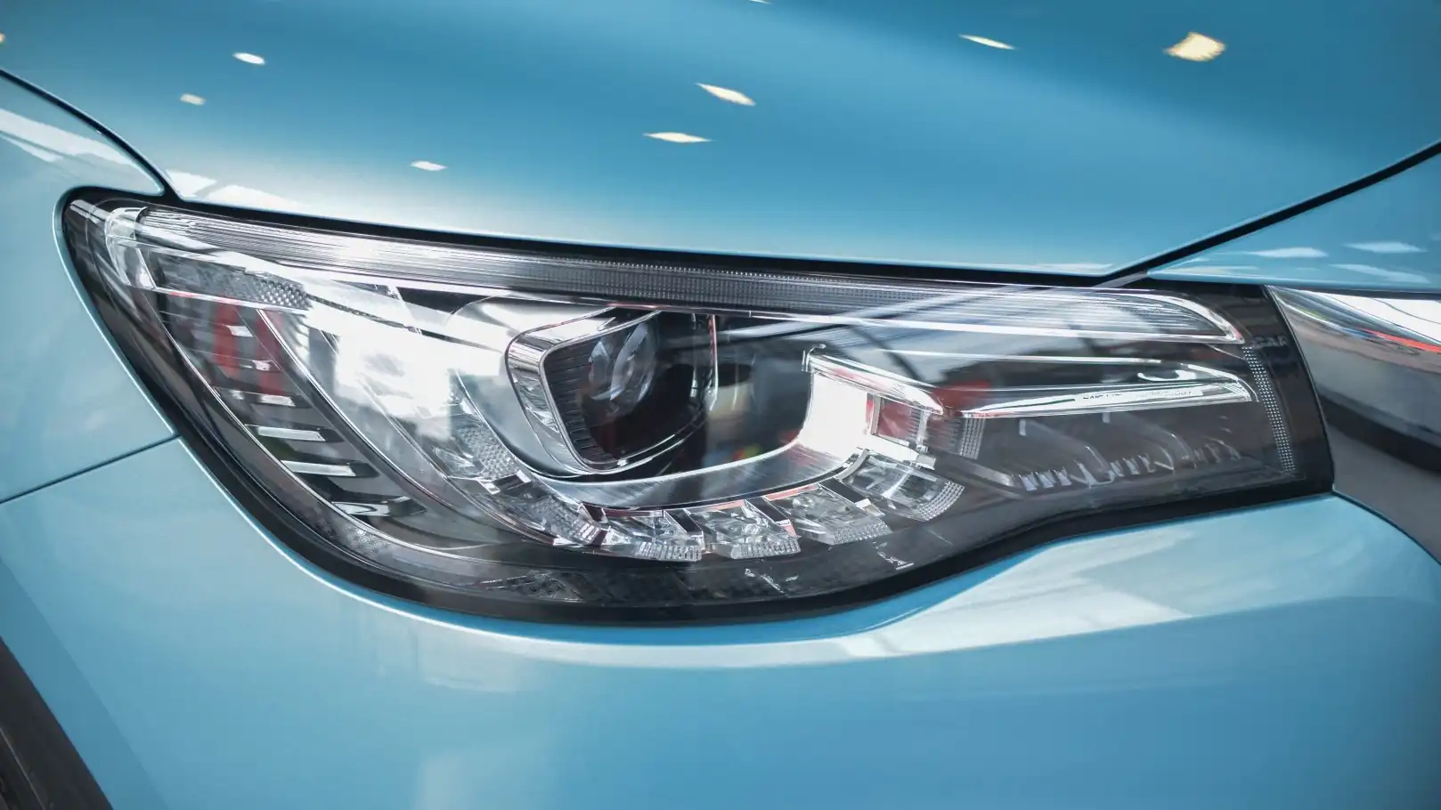 Nahaufnahme eines modernen Autoscheinwerfers mit bläulichem Licht