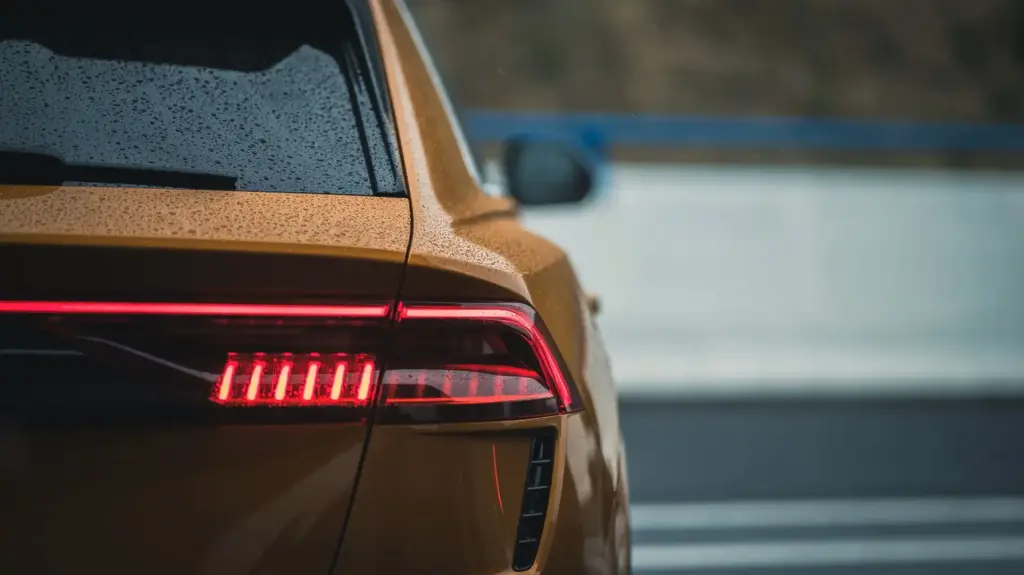 Leuchtendes rotes Rücklicht an einem nassen Auto bei Regen