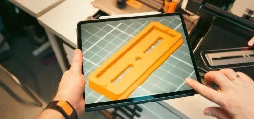 Person prüft ein 3D-Modell auf einem Tablet in einer Werkstatt mit 3D-Druckern