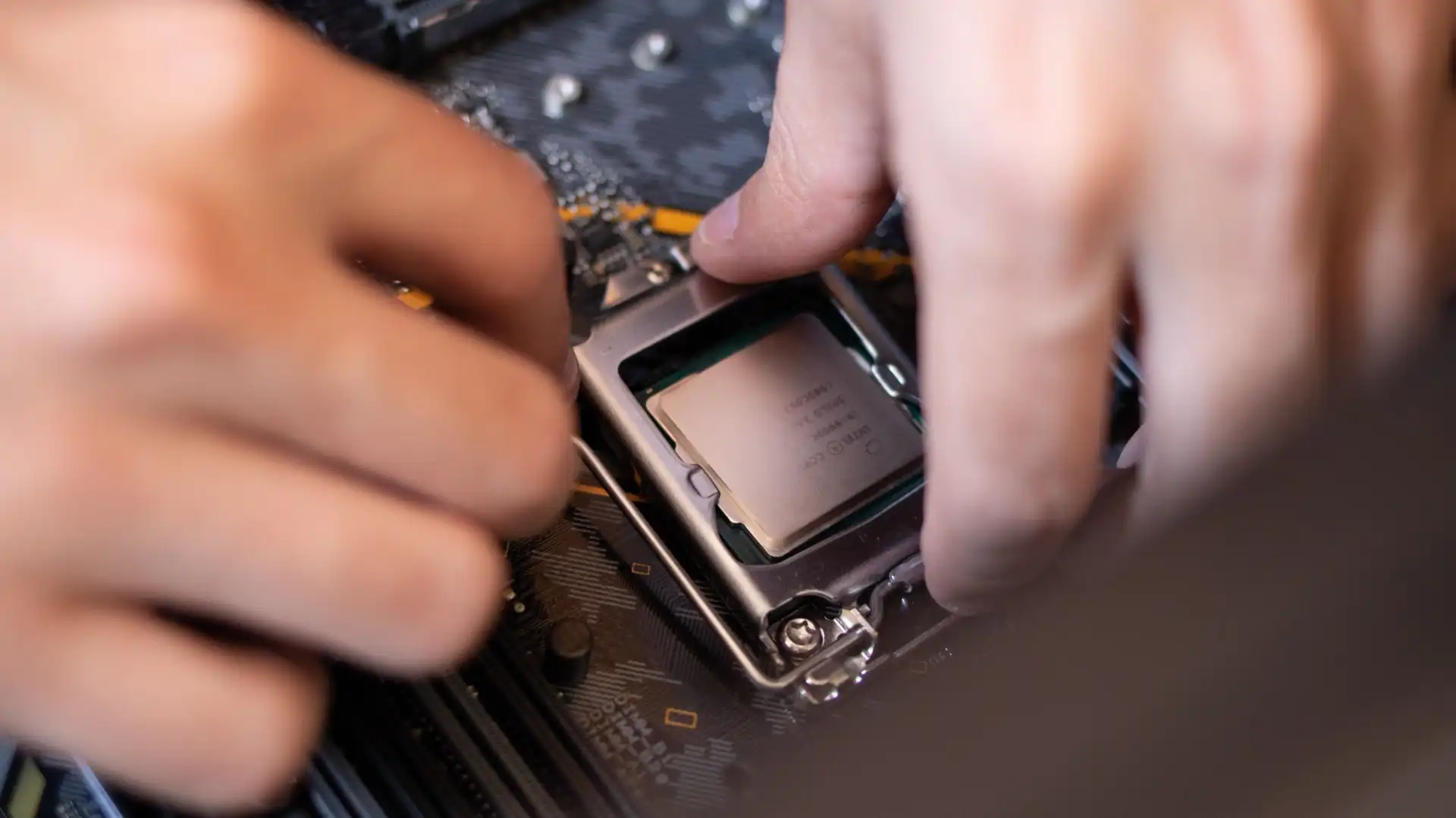 Hände setzen einen Prozessor auf das Mainboard eines PCs