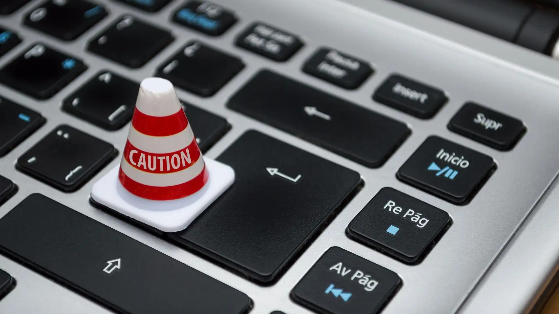 Kleiner weißer Warnkegel auf einer Computertastatur – Symbolbild für den Windows Defender Fehlalarm