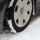 Nahaufnahme eines Autoreifens auf schneebedeckter Straße