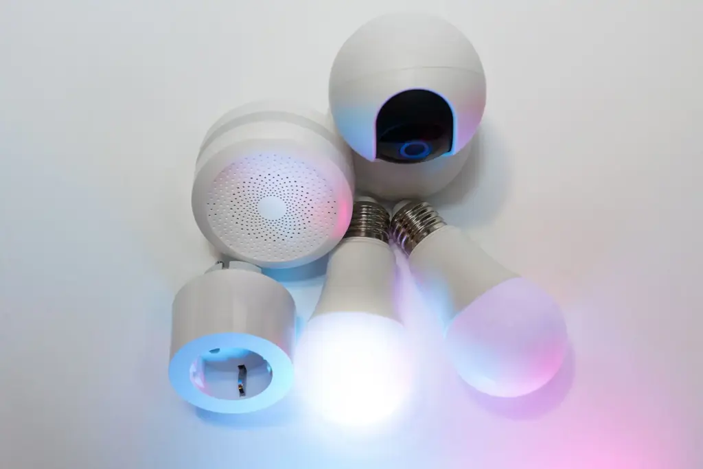 Smart-Home-Geräte auf dunklem Hintergrund: Glühbirnen, Kamera und Hub