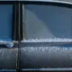 Auto an einem kalten Wintermorgen, bedeckt von Schnee und Eis
