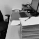 Schreibtisch mit verstreuten Papieren, Dokumenten und einem Computer