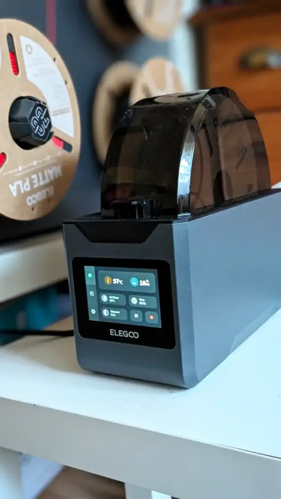 Elegoo H1 HT Filamenttrockner in seitlicher Ansicht mit getöntem Deckel und Display während der PLA-Trocknung
