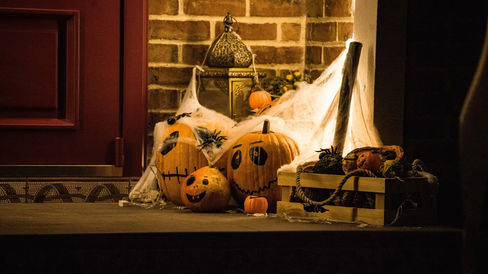 Halloween-Dekoration an einer Türschwelle mit geschnitzten Kürbissen