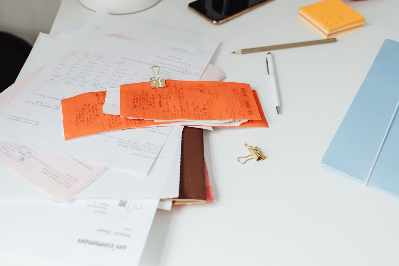 Kassenbons und Belege auf einem Schreibtisch mit Büromaterial