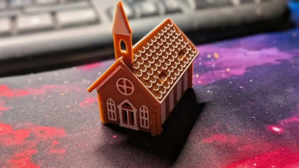 Zusammengebaute Lebkuchenkirche aus dem 3D-Drucker in Braun und Weiß mit Glockenturm und Zuckerguss-Dach