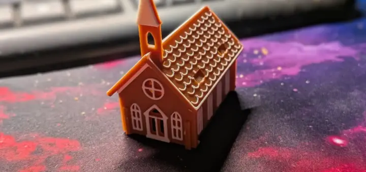 Zusammengebaute Lebkuchenkirche aus dem 3D-Drucker in Braun und Weiß mit Glockenturm und Zuckerguss-Dach